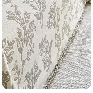 Detail view of pastoral style floral sofa cover blanket with texture and fringe trim.