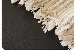 Chenille sofa blanket close-up detail, thick textured woven fabric with elegant fringe.