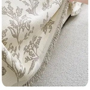 Pastoral style woven sofa blanket cover with delicate floral pattern and elegant fringe edges.