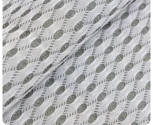 Detailed close-up of premium textured sofa cushion fabric with breathable mesh pattern.