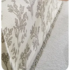 Detail shot of pastoral style sofa cover blanket with floral print and fringe edge texture.