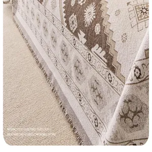 Chenille sofa cover blanket detail showing retro boho geometric weave texture and tassels.