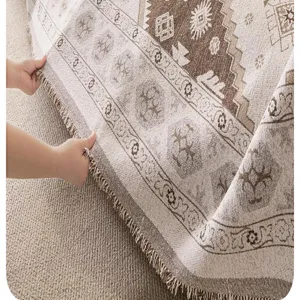 Chenille sofa blanket detail showing retro geometric patterns and soft fringe edge texture.