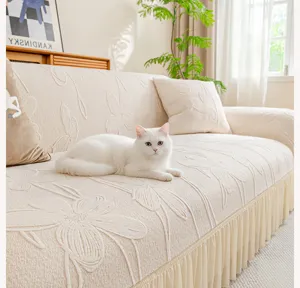Detailed view of off-white jacquard sofa cover with elegant ruffled skirt and floral pattern.