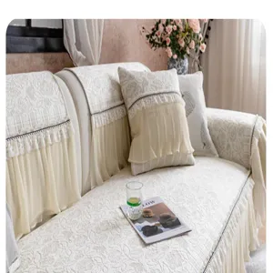Gros plan detaille de la housse de canape en soie glacee beige avec jupe plissee.