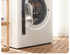 Front load washing machine detail shot in bright modern home laundry room interior setup.