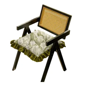 French vintage style dining chair with green leaf pattern ruffle cushion and rattan back.