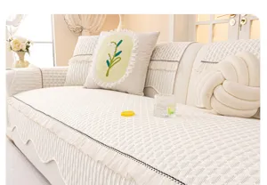 Cream chenille sofa cover detail showing textured fabric, elegant ruffles and cute decorative pillows.
