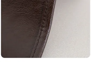 Detailaufnahme des dunkelbraunen Kunstleder-Sofakissens mit feiner Textur und Naht.
