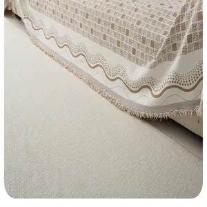 Detailed view of beige brown geometric patterned sofa cover throw blanket with fringe trim.