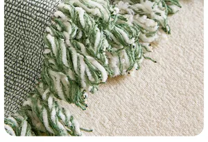 Nahaufnahme der retro gruen und weiss Chenille Sofatuch Stofftextur und Fransen Details.