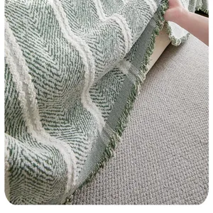 Detailansicht des Retro-Chenille-Sofabezugs mit grünem Zickzack-Muster und Fransen, weich.