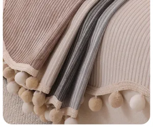 Detailaufnahme des Chenille Sofabezugs mit geripptem Stoff und dekorativer Fransenborte.