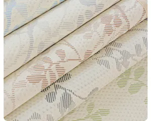 Detailansicht gerollter sommerlicher Kühl-Sofakissen-Stoffe mit feiner Blatt-Webstruktur.
