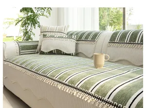 Detailansicht des französischen grün-weißen Sofakissens mit eleganter Fransenverzierung.