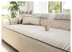 Detailansicht französischer gestreifter Sofabezug mit eleganten Quasten für die Wohnzimmereinrichtung.