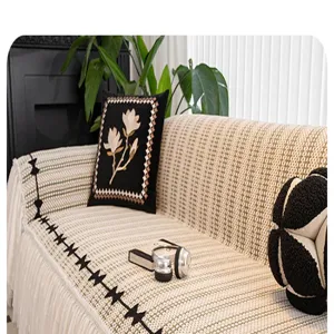 Textured chenille sofa cover detail in beige and green, featuring elegant decorative fringe.