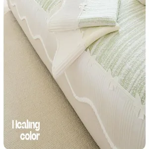 Detailed view of the green and white striped ice silk sofa cover with bows and wavy edge.