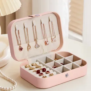 Portable pink travel jewelry box with multiple compartments, necklace hooks, and ring slots.