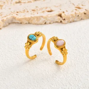 Detail shot of women's 18k gold stainless steel open ring with oval natural stone and flower.