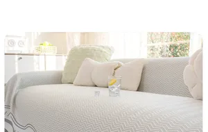 Detail shot showing the texture and pattern of the cooling sofa towel cover in a cozy living room.