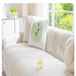 Close-up of beige knitted sofa cushion in cozy living room setting with decorative throw pillow.