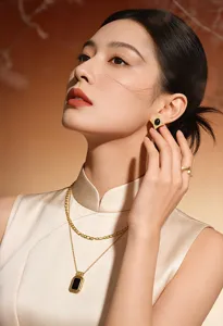 Elegant vintage gold jewelry set featuring geometric black stone earrings and layered necklace.