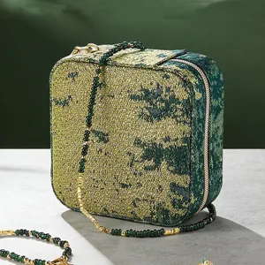 Green woven portable jewelry box travel case for rings, earrings and necklaces storage.