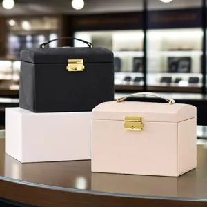 Minimalist leather jewelry storage box with lock and handle for rings, necklaces, and earrings.