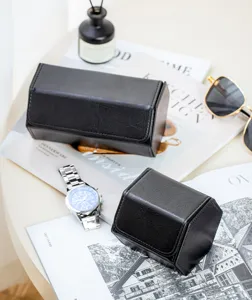 Detailed close-up view of black PU leather watch roll travel storage box styled with props.