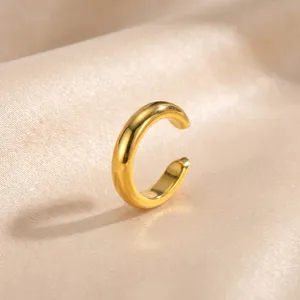 Minimalistische goldene C-förmige Ohrklemme Detailansicht, clip-on Design, glatte Textur.
