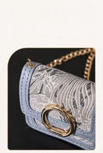 Close-up detail of retro jacquard earphone bag, featuring exquisite fabric and golden chain.