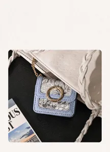 Close-up detail of vintage jacquard mini earphone storage bag with elegant gold ring buckle.