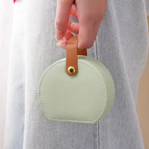 Portable round jewelry storage box with handle, mini travel case for rings and earrings.