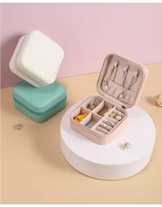 Portable travel jewelry box with multiple ring slots, necklace hooks and compartments for safe storage.