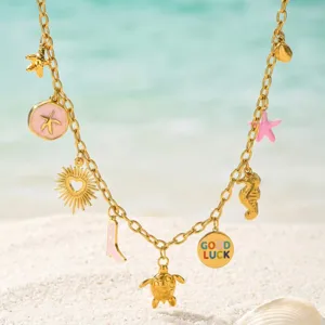 Detailansicht der goldenen Ozean-Charms-Halskette mit Glücksmünze und Schildkrötenanhänger.