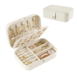Portable travel jewelry box with multiple compartments for rings, necklaces, and earrings.