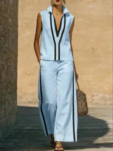 Detailed shot of light blue sleeveless top and wide-leg pants with black contrast trim.