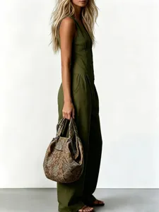 Vista dettagliata di una tuta elegante senza maniche in verde oliva con una borsa chic.