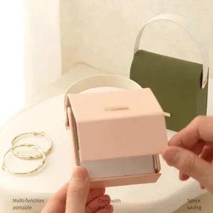 Portable travel jewelry box with minimalist color block design and metal clasp closure.