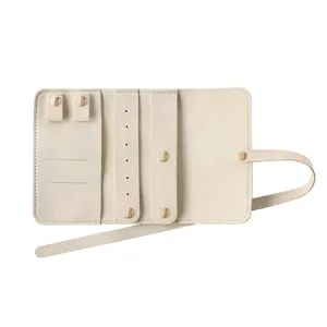 Portable travel jewelry organizer bag, beige PU leather jewelry roll case for rings and necklaces.