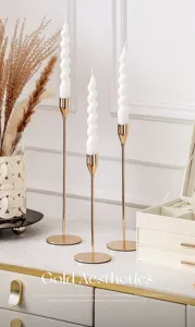 Nordic luxury gold candle holder with white spiral candle for romantic dining room decor.