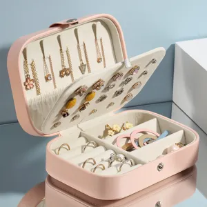 Portable pink PU leather jewelry organizer box for travel, rings, necklaces, and earrings storage.