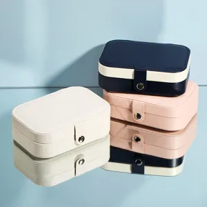 Portable travel jewelry organizer box with compartments for earrings, necklaces, and rings.