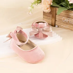 Detailed view of cute pink velvet baby princess shoes with a sweet satin bow soft sole.