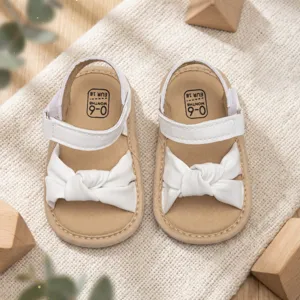 Detail shot of cute baby sandals with sweet bowknot design and comfortable soft sole for infants.