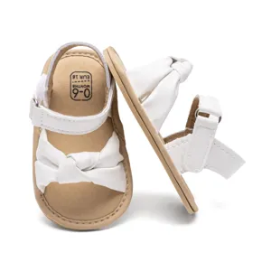 Infant white bowknot sandals, comfortable soft sole baby walking shoes for sweet summer wear.