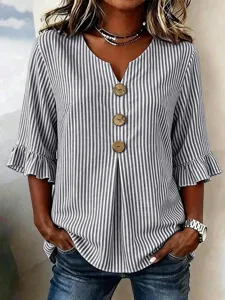 Close-up detail of the vertical striped V-neck blouse with big buttons and flare sleeves.