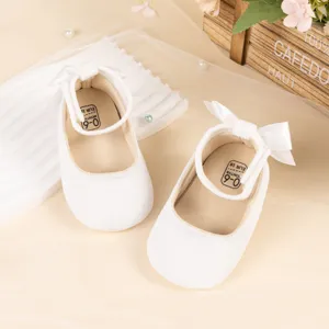 White velvet baby princess shoes with cute bow and soft sole, perfect for infant girls.