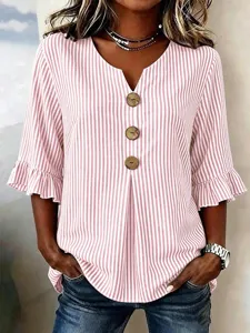 Close-up details of the women vertical striped V-neck top with large buttons and ruffle sleeves.